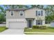 Charming two-story home features blue shutters and a well-maintained lawn and a two car garage at 203 Lovely Ct, Plant City, FL 33566