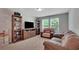 Comfortable living room with a large TV, cozy seating, and shelving, ideal for relaxation and entertainment at 203 Lovely Ct, Plant City, FL 33566
