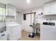 This laundry room features a utility sink, washer, dryer, and overhead cabinets at 4921 Marlin Dr, New Port Richey, FL 34652