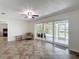 Spacious living room featuring ceramic tile floors and sliding glass doors leading to an enclosed lanai at 4921 Marlin Dr, New Port Richey, FL 34652