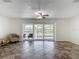 Bright living room with ceramic tile flooring, ceiling fan, and sliding glass doors to the outside at 4921 Marlin Dr, New Port Richey, FL 34652