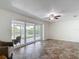 Bright living room with ceramic tile flooring and sliding glass doors overlooking outdoor area at 4921 Marlin Dr, New Port Richey, FL 34652