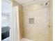 Walk-in shower features tiled walls, mosaic tile accent, and handheld shower head at 4921 Marlin Dr, New Port Richey, FL 34652
