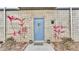 Entrance to unit with blue door and minimalist landscaping, including pink flowering plants at 5008 S Macdill Ave # 12, Tampa, FL 33611