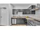 Modern kitchen featuring dark cabinets, stainless steel appliances, and stylish backsplash at 5008 S Macdill Ave # 12, Tampa, FL 33611