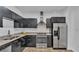 Modern kitchen featuring dark cabinets, stainless steel appliances, and stylish backsplash at 5008 S Macdill Ave # 12, Tampa, FL 33611