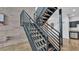 Modern black metal staircase leading to living area and kitchen with stainless steel appliances at 5008 S Macdill Ave # 12, Tampa, FL 33611