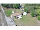 Aerial view showcasing the home with a driveway, shed, and a lush green lawn at 8318 Franklin Rd, Plant City, FL 33565