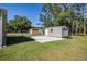 Spacious backyard featuring a metal shed on a concrete pad surrounded by green grass at 8318 Franklin Rd, Plant City, FL 33565