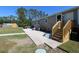 Wide open backyard with a concrete patio area, shed and back entrance with wooden stairs at 8318 Franklin Rd, Plant City, FL 33565