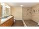 Modern bathroom featuring double sinks, a tiled walk-in shower, and wood-look flooring at 8318 Franklin Rd, Plant City, FL 33565