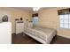 Cozy bedroom featuring hardwood floors, neutral walls, ceiling fan, natural light, and minimalist white furniture at 8318 Franklin Rd, Plant City, FL 33565