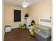 Neutral bedroom with ceiling fan, hard wood floors, and an array of toys at 8318 Franklin Rd, Plant City, FL 33565