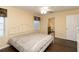 Comfortable bedroom featuring hardwood floors, neutral walls, ceiling fan, natural light, and open doorway to bathroom at 8318 Franklin Rd, Plant City, FL 33565