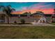 Charming single-story home with neutral siding, palm tree, manicured lawn, and quaint front porch with rocking chairs at 8318 Franklin Rd, Plant City, FL 33565