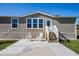 Close up of attractive single-story home with neutral siding and charming front porch adorned with rocking chairs and manicured lawn at 8318 Franklin Rd, Plant City, FL 33565