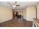Open concept living area with hardwood floors, ceiling fan, and ample natural light with an open view of the kitchen at 8318 Franklin Rd, Plant City, FL 33565