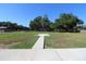 Spacious lot with grass, trees, and a narrow concrete path at 8318 Franklin Rd, Plant City, FL 33565