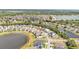 An aerial view displays a home in a pond-filled community surrounded by mature trees and well-maintained lawns at 9015 Spruce Creek Cir, Riverview, FL 33578