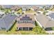Aerial view of a house with solar panels on the roof, situated in a residential neighborhood near a lake at 9015 Spruce Creek Cir, Riverview, FL 33578