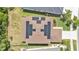 Aerial view of a home with solar panels on the roof, a well-maintained lawn, and landscaping at 9015 Spruce Creek Cir, Riverview, FL 33578