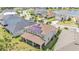 Aerial view of the house showcasing the roof's solar panels and screened lanai at 9015 Spruce Creek Cir, Riverview, FL 33578