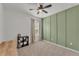 Minimalist bedroom with green accent wall and modern decor features neutral carpet at 9015 Spruce Creek Cir, Riverview, FL 33578