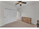 Bright bedroom with neutral carpet features double closet doors and wood dresser at 9015 Spruce Creek Cir, Riverview, FL 33578