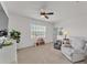Bright bonus room features neutral carpet, ceiling fan and cozy gray recliner for relaxing at 9015 Spruce Creek Cir, Riverview, FL 33578