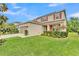 Two-story home featuring well-maintained lawn and manicured landscaping at 9015 Spruce Creek Cir, Riverview, FL 33578