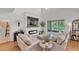 A sunlit living room with a fireplace, large TV, and comfortable couches at 9015 Spruce Creek Cir, Riverview, FL 33578