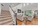 Bright living room with hardwood floors, staircase, and a cozy seating area at 9015 Spruce Creek Cir, Riverview, FL 33578