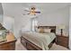Bright main bedroom featuring a large bed, ceiling fan, and dual nightstands at 9015 Spruce Creek Cir, Riverview, FL 33578