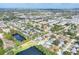 An aerial view of the neighborhood with the property indicated by a red arrow showing proximity to shopping and green spaces at 13032 Cumberland Dr, Largo, FL 33773