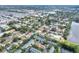 An aerial view of the neighborhood with the property indicated by a red arrow showing proximity to shopping and green spaces at 13032 Cumberland Dr, Largo, FL 33773