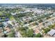 An aerial view of the neighborhood with the property indicated by a red arrow showing proximity to shopping and green spaces at 13032 Cumberland Dr, Largo, FL 33773