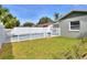 The fenced backyard features a sparkling pool, lush grass, and secure gate for privacy and enjoyment at 13032 Cumberland Dr, Largo, FL 33773