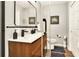 Well lit bathroom features a double sink vanity, framed mirror, and modern black fixtures at 13032 Cumberland Dr, Largo, FL 33773