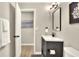 Bathroom features a modern vanity, decorative mirror, and an open doorway showcasing wall art at 13032 Cumberland Dr, Largo, FL 33773
