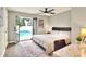 Cozy bedroom with pool access, a ceiling fan, and a comfortable workspace at 13032 Cumberland Dr, Largo, FL 33773