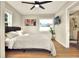 Bright bedroom featuring hardwood floors, a ceiling fan, and an en suite bathroom with walk-in shower at 13032 Cumberland Dr, Largo, FL 33773