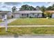 Quaint one-story home featuring a well-maintained lawn and lovely landscaping at 13032 Cumberland Dr, Largo, FL 33773