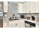 Close up on sink area with modern appliances, hexagon backsplash, and quartz countertop at 13032 Cumberland Dr, Largo, FL 33773