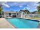 Backyard pool surrounded by concrete patio and white fencing for privacy at 13032 Cumberland Dr, Largo, FL 33773
