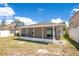 A sunny backyard featuring a screened-in back porch with a white fence border at 14385 Saltby Pl, Spring Hill, FL 34609