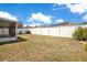 Fenced backyard and screened in porch of home with view of neighbor's home with solar panels at 14385 Saltby Pl, Spring Hill, FL 34609