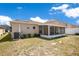View of the backyard and screened in porch of this single Gathering home on a sunny day at 14385 Saltby Pl, Spring Hill, FL 34609