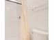 Modern bathroom featuring shower with a peach shower curtain and toilet with a shiny metal handle at 14385 Saltby Pl, Spring Hill, FL 34609