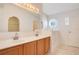 Bathroom featuring a walk-in tub, double sink vanity, and an arched doorway at 14385 Saltby Pl, Spring Hill, FL 34609