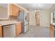 Kitchen view featuring stainless steel refrigerator, wood cabinets and tile backsplash at 14385 Saltby Pl, Spring Hill, FL 34609